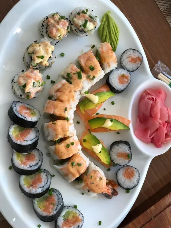 Assiette de sushis variés avec accompagnements.