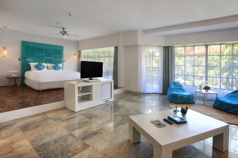 Une chambre lumineuse avec un grand lit et un espace détente.