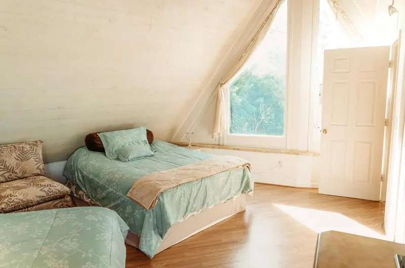 Une chambre lumineuse avec un lit et un canapé près d'une fenêtre.