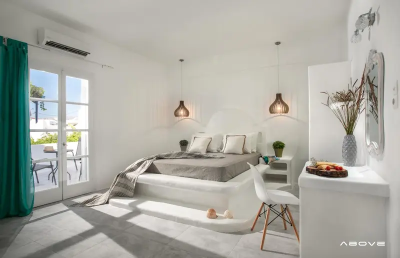 Une chambre lumineuse avec un lit double et une décoration minimaliste.