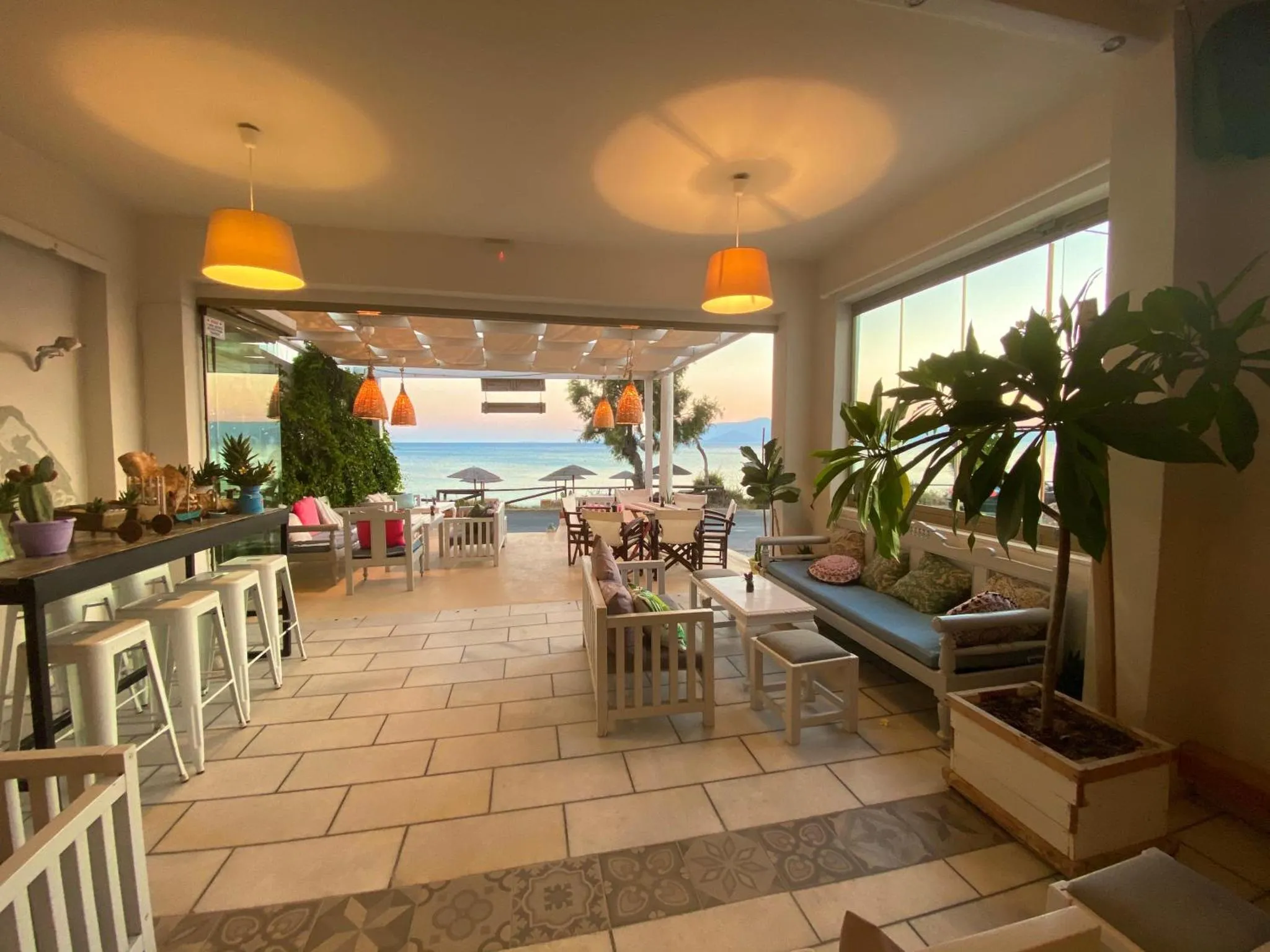 Espace de détente intérieur avec bar et vue sur la mer.