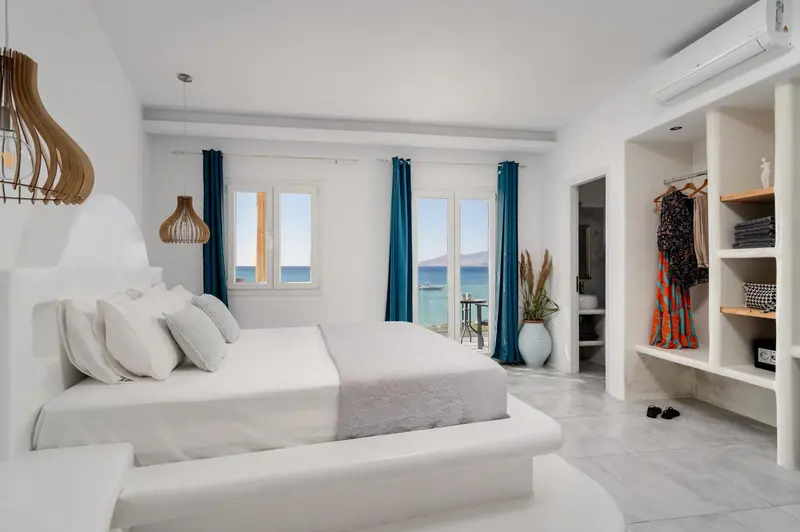 Une chambre lumineuse avec un grand lit et une vue sur la mer.