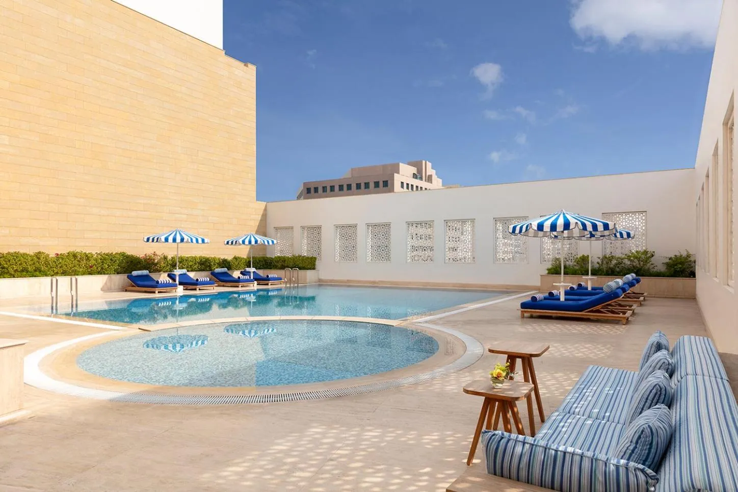 Terrasse avec piscine et mobilier de détente.