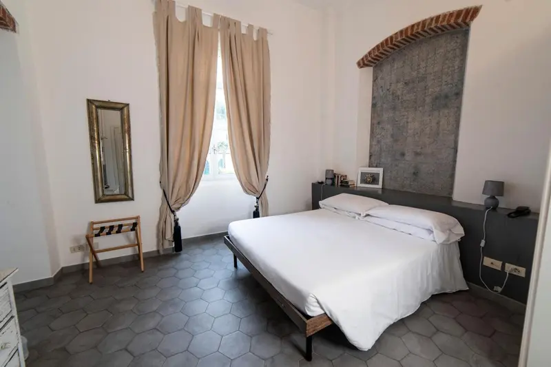 Une chambre lumineuse avec un grand lit et un mur en pierre.