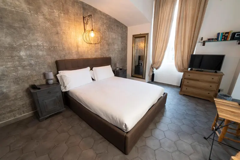Une chambre à coucher lumineuse avec un lit double et un mur texturé.