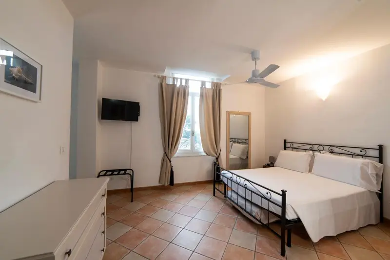Chambre lumineuse avec un lit double et une décoration sobre.