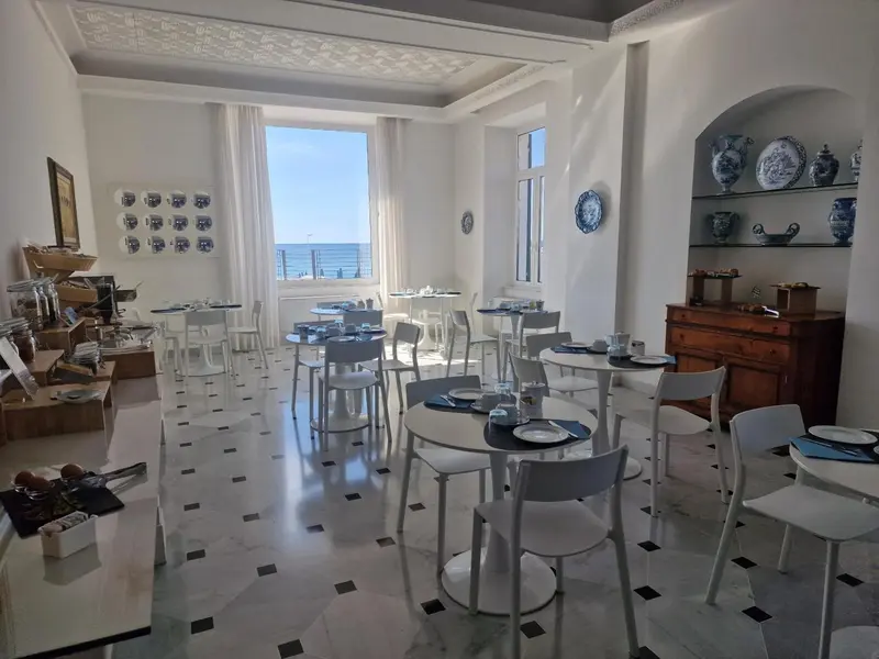Une salle lumineuse avec des tables dressées pour le repas.