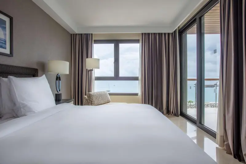 Une chambre lumineuse avec un grand lit et une vue sur la mer.