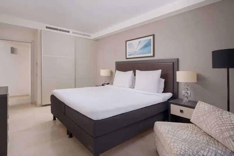 Une chambre lumineuse avec un grand lit et un coin salon.