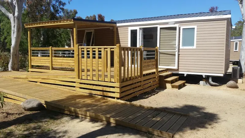 Mobil-home en bois avec terrasse et accès aménagé.
