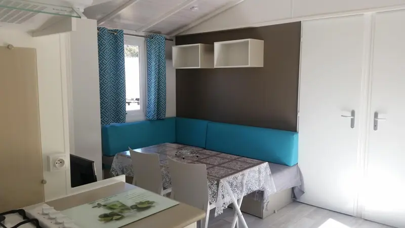 Intérieur lumineux d'un espace de vie avec une banquette et une table.
