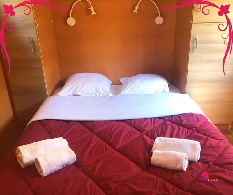 Un lit recouvert d'une courtepointe rouge est dispose dans une chambre.