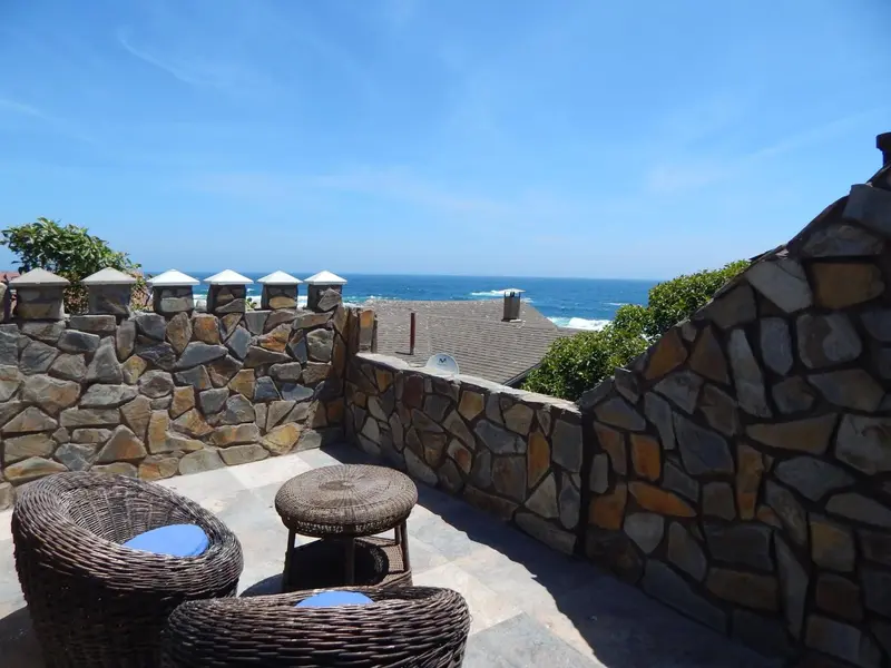 Terrasse en pierre avec mobilier d'extérieur donnant sur la mer.