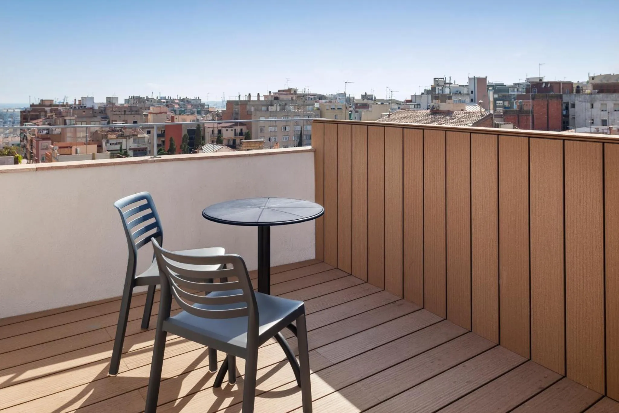 Terrasse avec mobilier de jardin et vue sur la ville.
