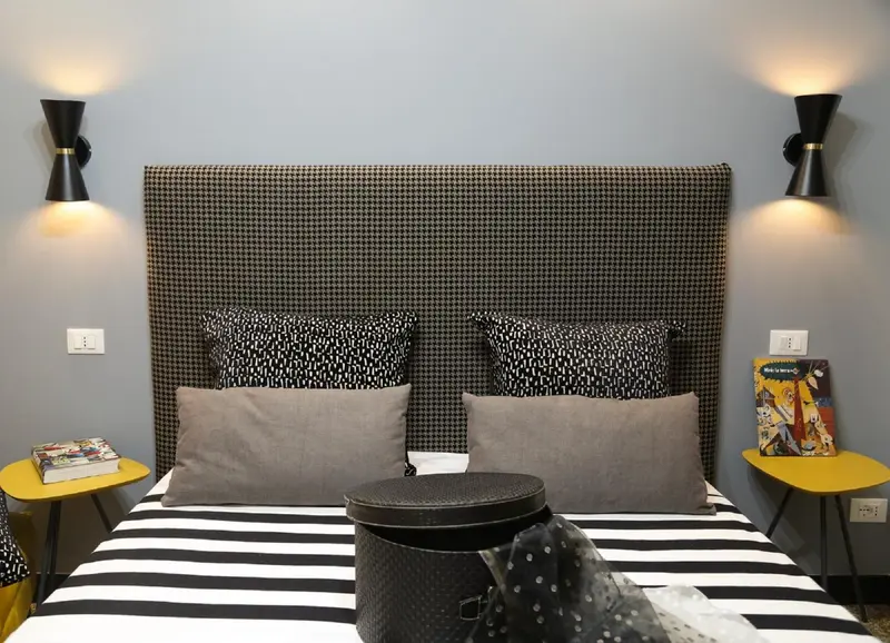 Un lit double avec une tête de lit à motifs et des oreillers décoratifs.