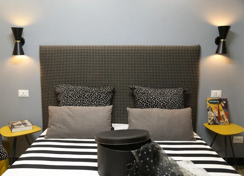 Un lit double avec une tête de lit à motifs et des oreillers décoratifs.