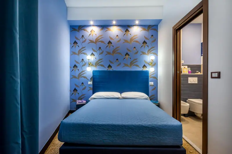 Une chambre avec un lit double et un mur décoré.