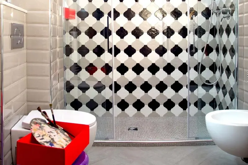 Une salle de bain moderne avec une douche à l'italienne et des motifs géométriques.