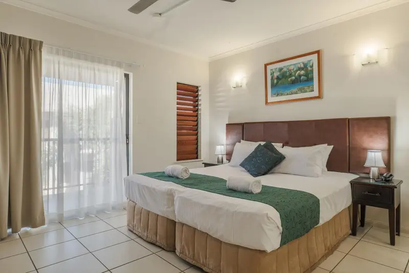 Une chambre lumineuse avec un grand lit et un accès à une terrasse.