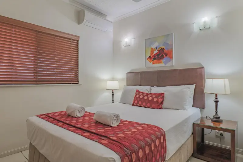 Une chambre lumineuse avec un grand lit et une décoration colorée.
