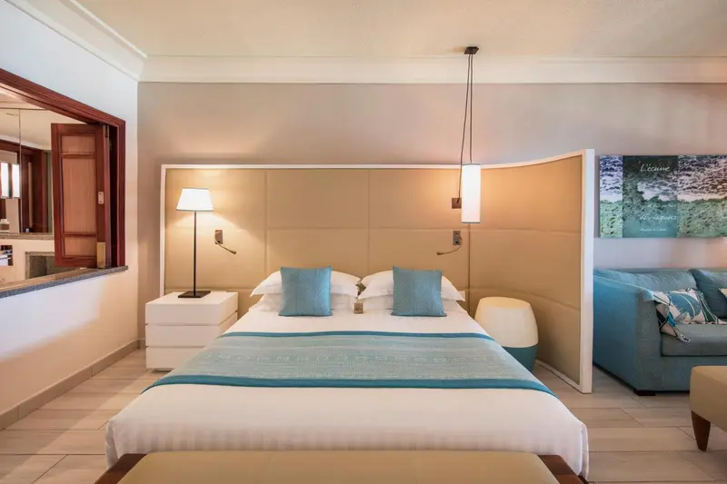Une chambre lumineuse avec un grand lit et un espace détente.