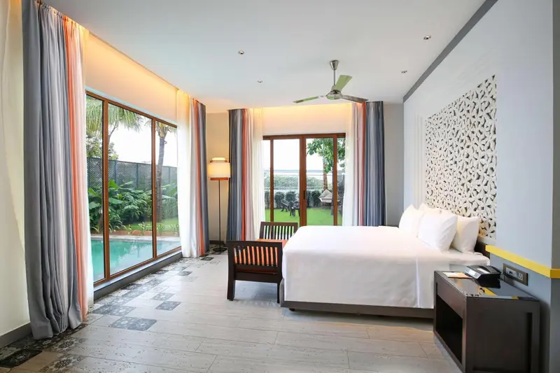 Une chambre lumineuse avec un grand lit et un accès à une terrasse.