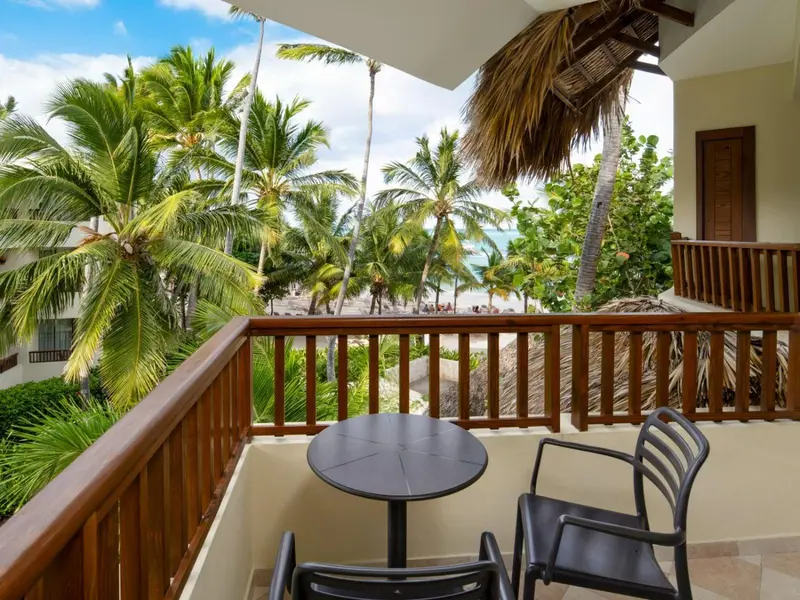 Terrasse avec mobilier d'extérieur donnant sur une plage de sable blanc et la mer.
