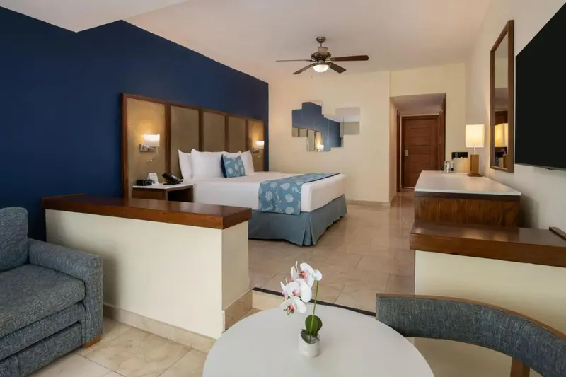 Une chambre lumineuse avec un grand lit et un coin salon.