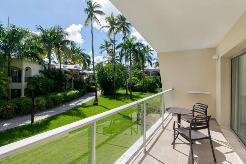 Terrasse avec mobilier d'extérieur donnant sur une végétation luxuriante.