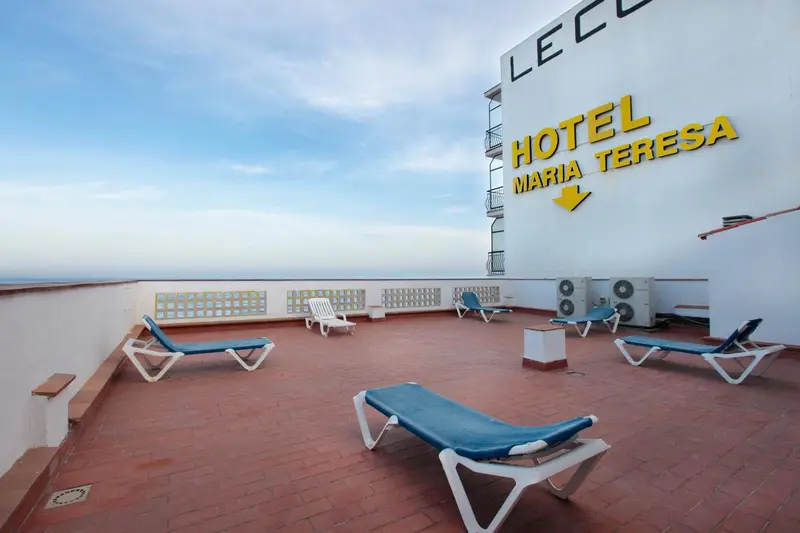 Terrasse avec chaises longues et vue sur la mer.