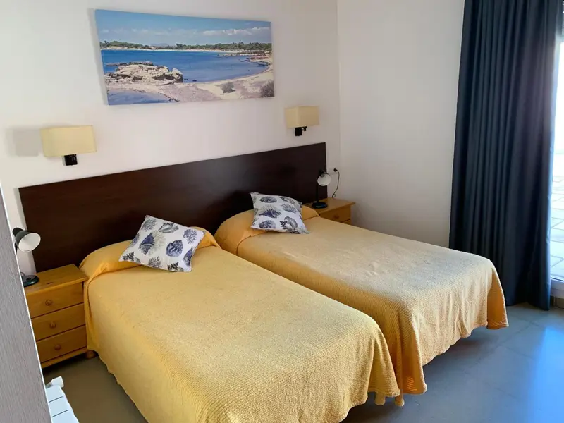 Une chambre lumineuse avec deux lits simples et une décoration marine.