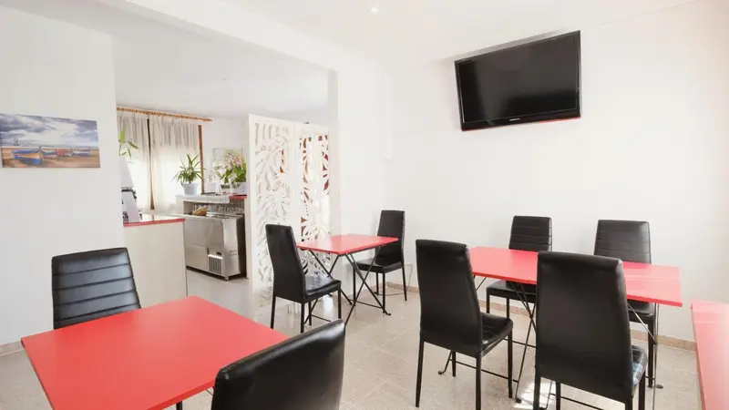 Une salle de restaurant avec des tables et des chaises.