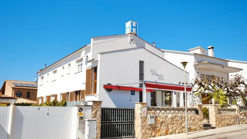 Bâtiment blanc à deux étages avec une marquise rouge au-dessus de l'entrée.