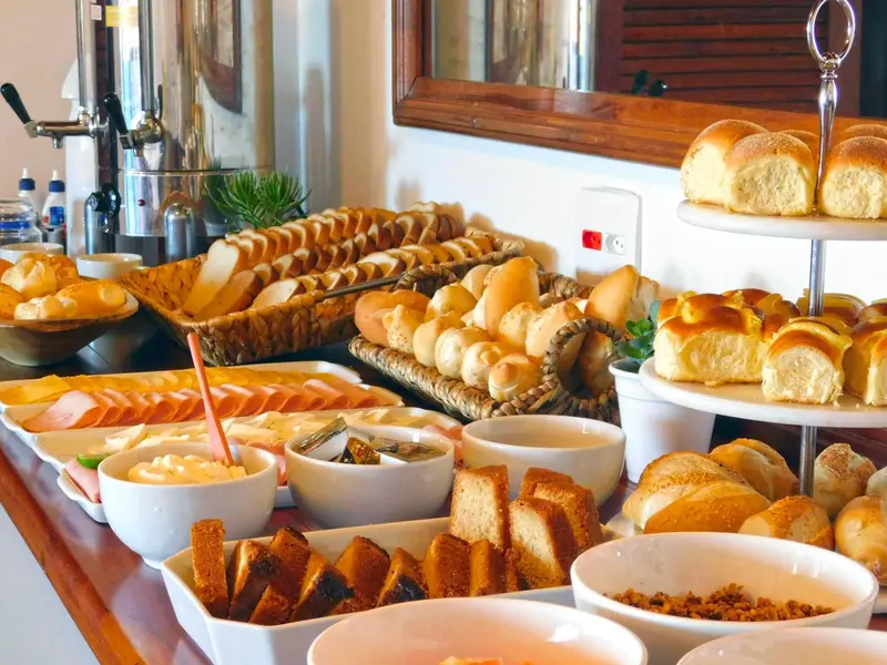 Un buffet propose une variété de pains, de viennoiseries et de charcuteries.