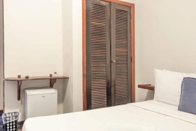 Une chambre lumineuse avec un lit et un petit bureau.