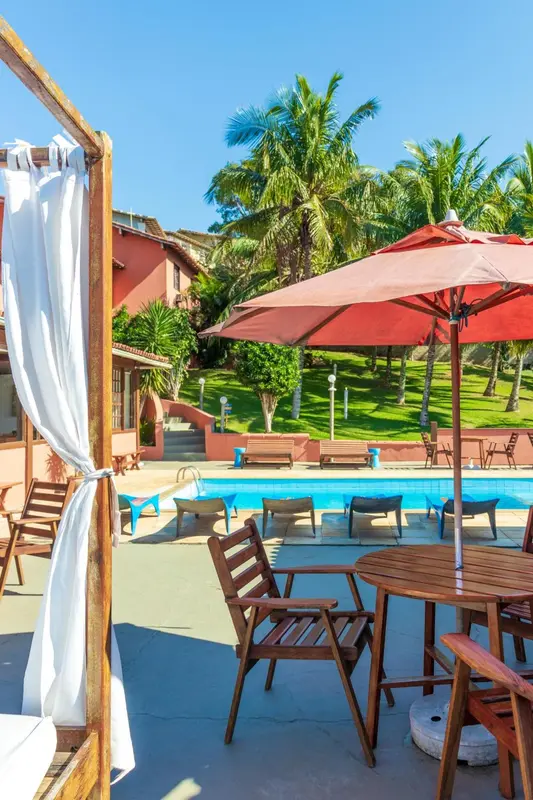 Terrasse avec mobilier de jardin et piscine au premier plan.
