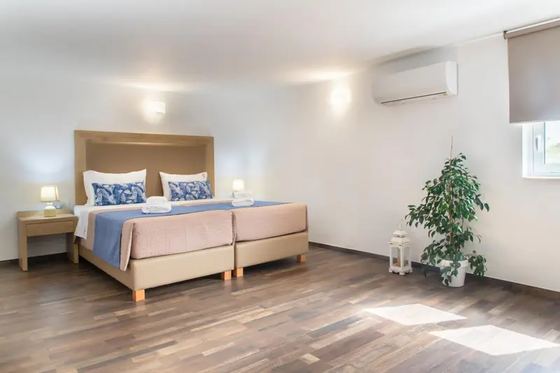 Une chambre lumineuse avec un grand lit et une décoration sobre.