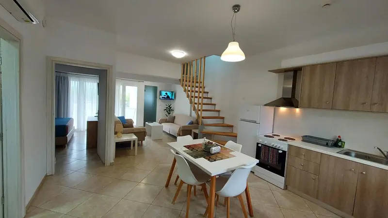 Espace de vie lumineux avec cuisine équipée et coin repas.