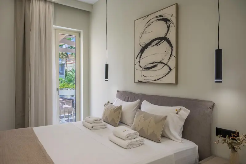 Une chambre lumineuse avec un grand lit et une vue sur une terrasse.