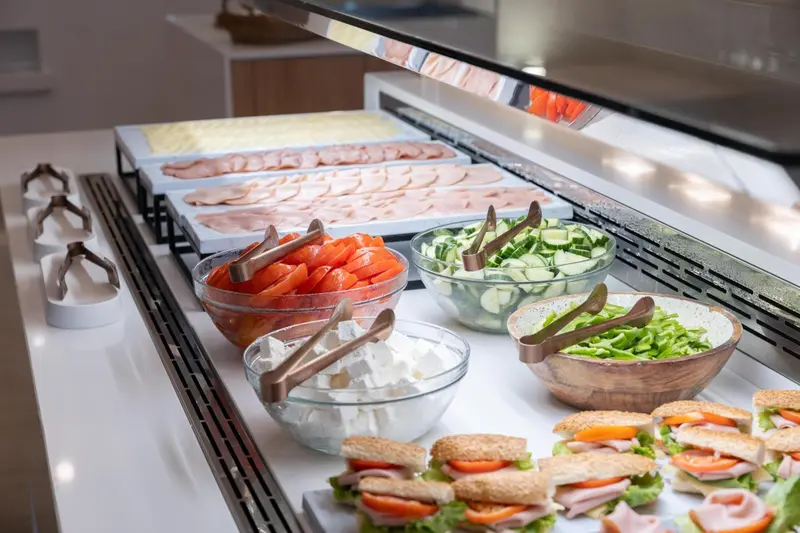 Un buffet propose une variété de charcuteries, de fromages et de salades.