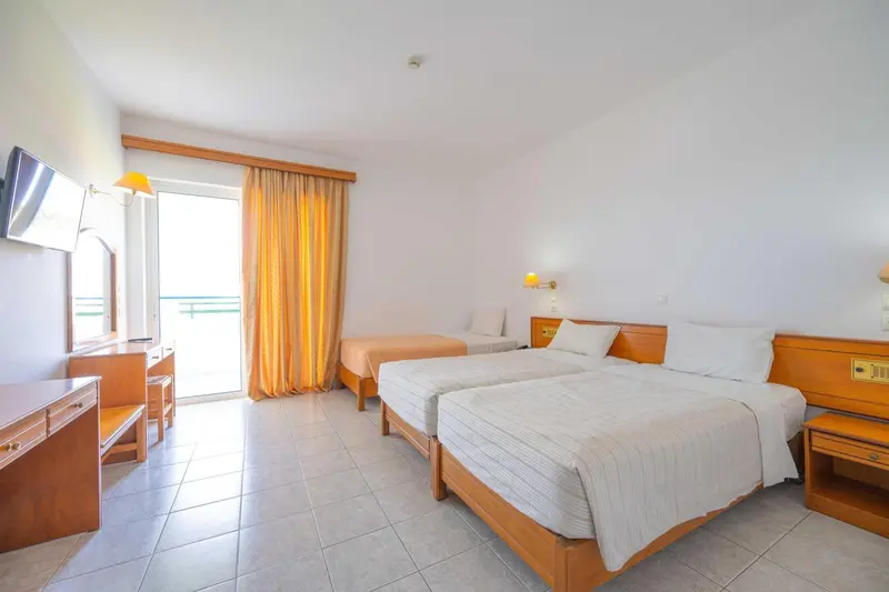 Chambre lumineuse avec deux lits simples et une vue sur l'extérieur.