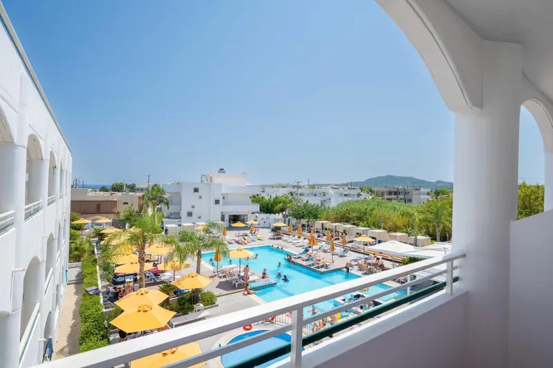Vue aérienne sur une piscine entourée de transats et de parasols.