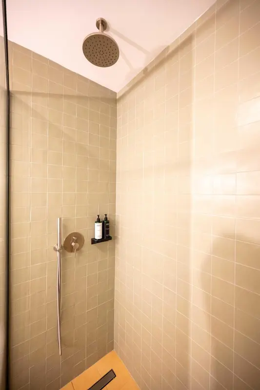 Douche à l'italienne dans une salle de bain carrelée.