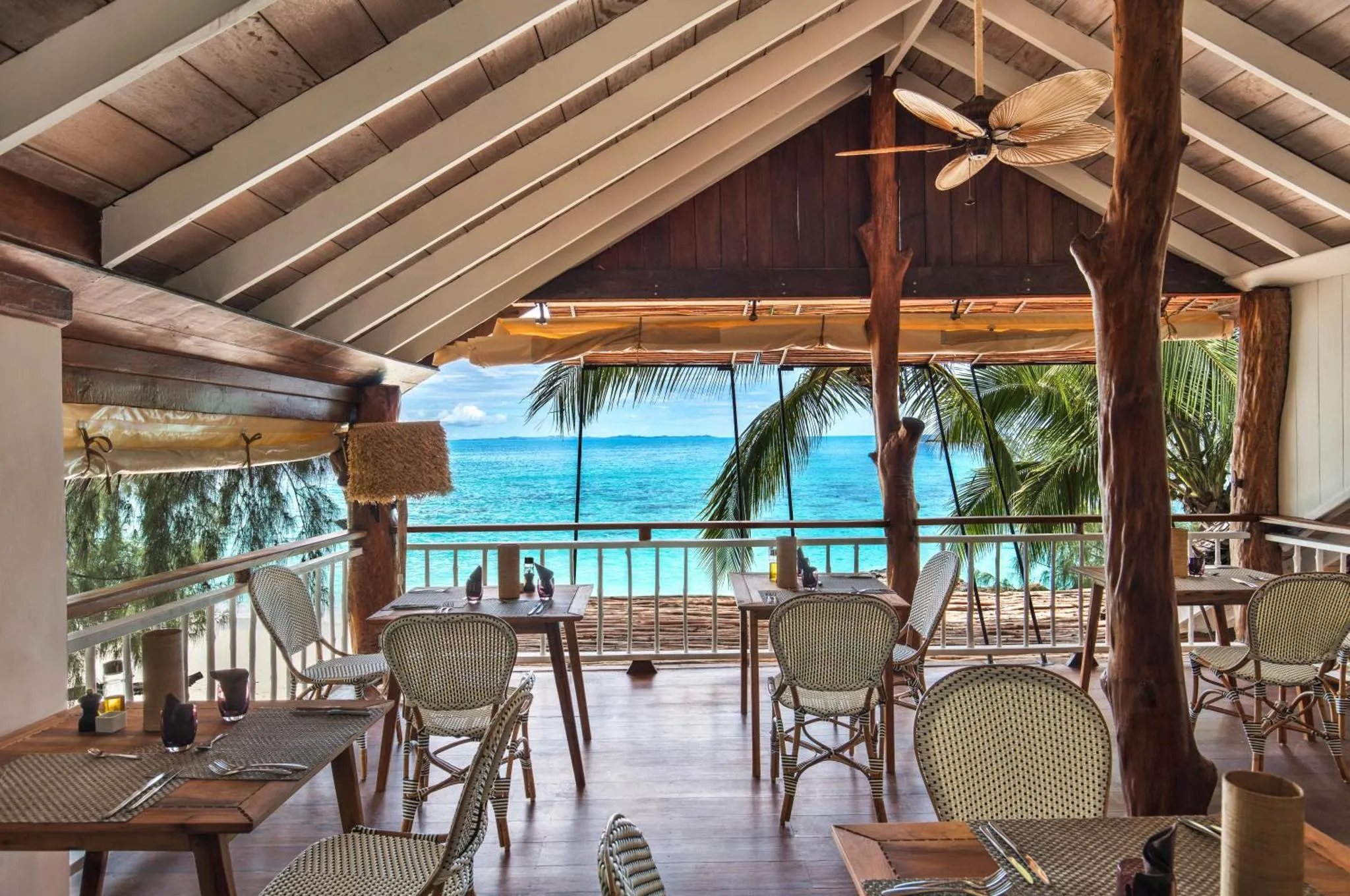 Une salle à manger ouverte sur une vue de mer.