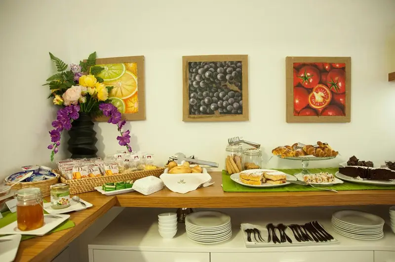 Un buffet propose des viennoiseries, des fruits et des pâtisseries.