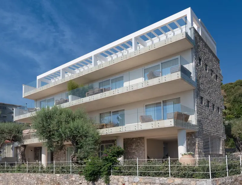 Bâtiment moderne à plusieurs étages avec des balcons et une façade en pierre.
