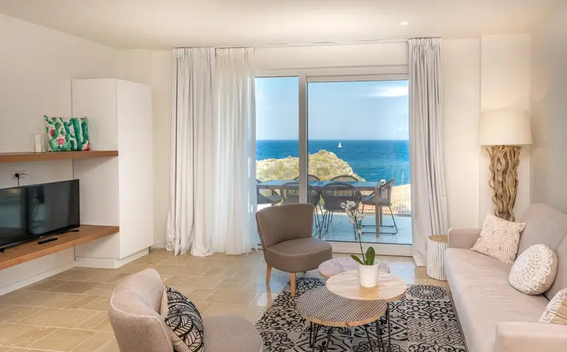 Un salon lumineux s'ouvre sur une terrasse avec vue sur la mer.
