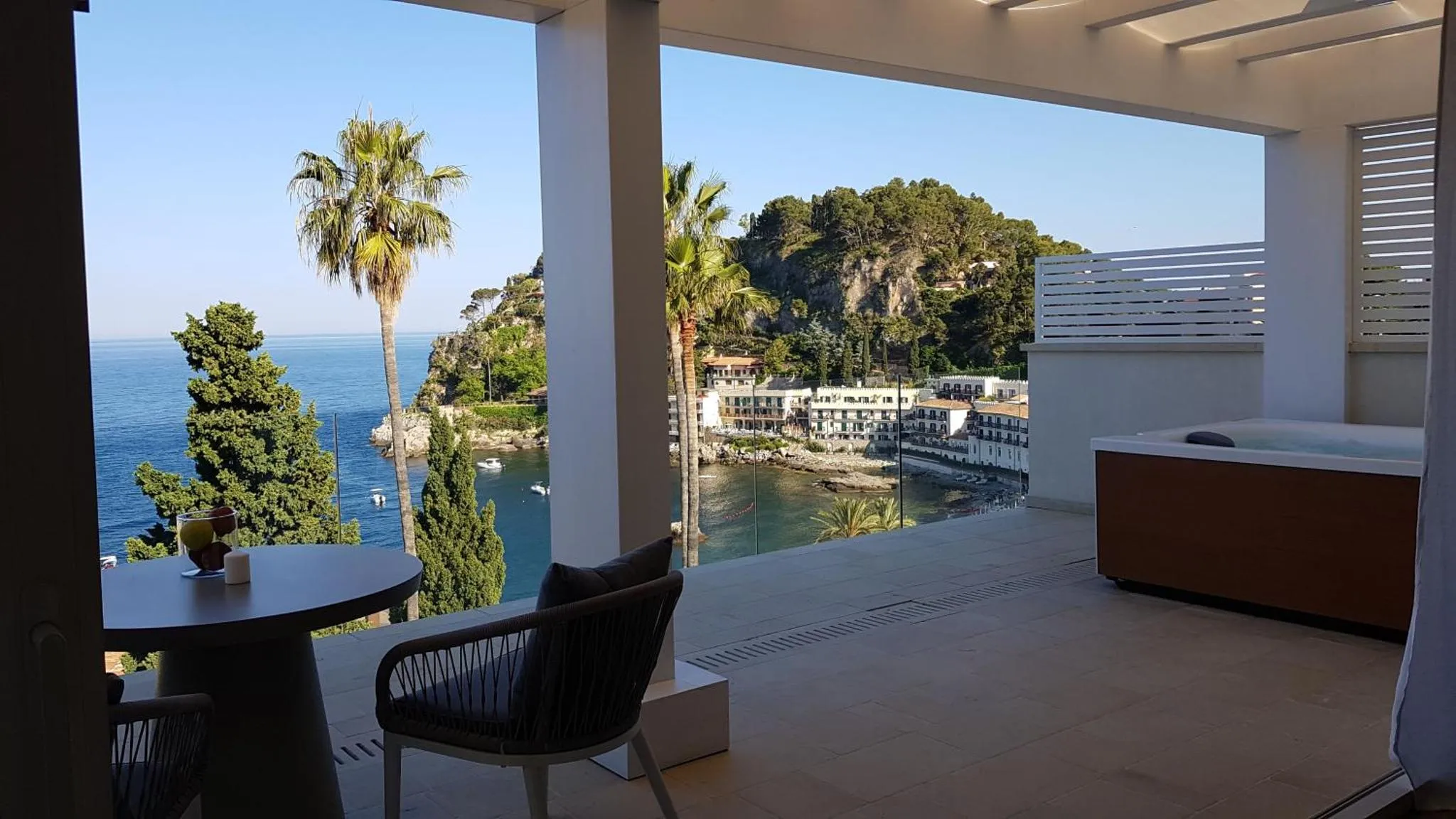 Terrasse avec mobilier de jardin et vue sur la mer.