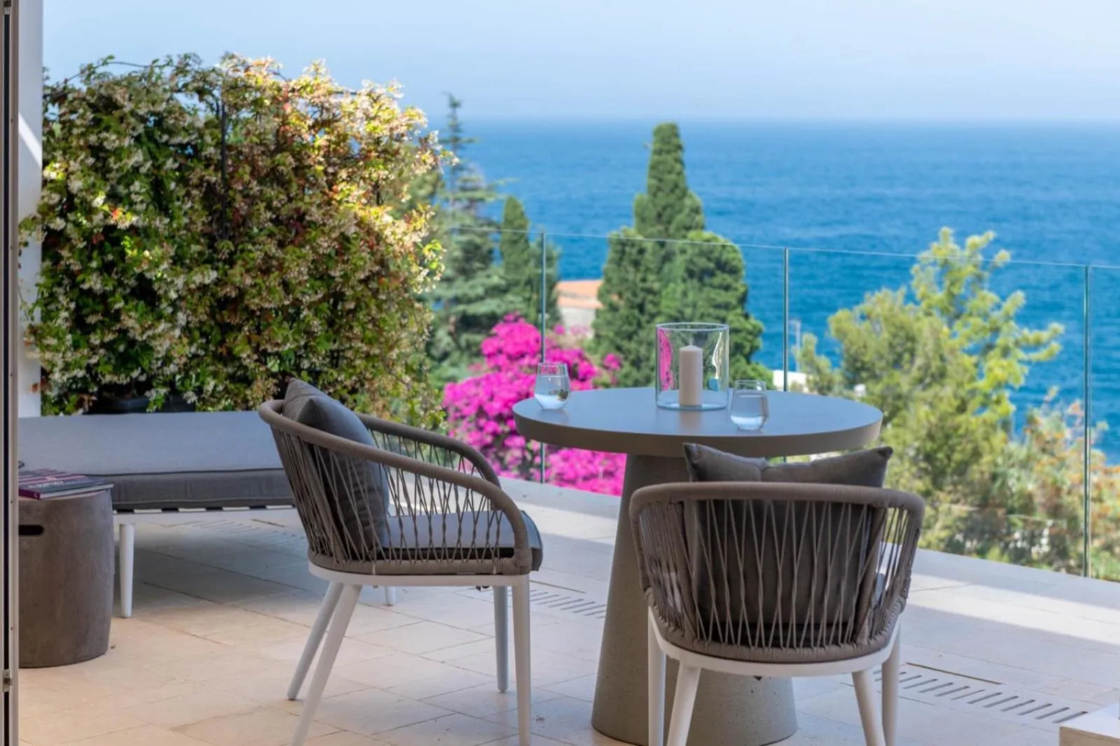 Terrasse avec mobilier d'extérieur et vue sur la mer.
