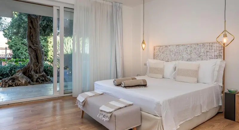 Une chambre lumineuse avec un grand lit et un accès à une terrasse.